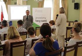 Pokaż zdjęcie: Uczestnik spotkania z mikrofonem udziela się w dyskusji