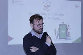 Pokaż zdjęcie: mężczyzna w okularach z mikrofonem