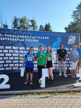 Pokaż zdjęcie: Trzy młode dziewczyny pozują na podium z medalami