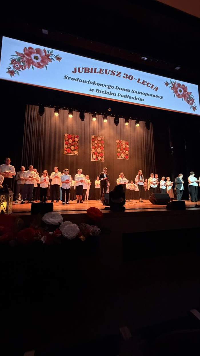 Pokaż zdjęcie: Uczestnicy Środowiskowego Domu Samopomocy w Bielsku Podlaskim podczas wspólnego występu na scenie z okazji jubileuszu 30-lecia placówki.