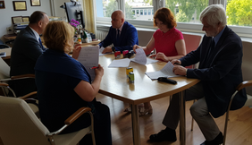 5 osób przy stole, podpisują dokumenty, od lewej kobieta, mężczyzna, po drugiej stronie stołu mężczysna kobieta, mężczyzna