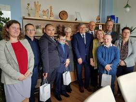 Grupa ok 10 osób, mężczyzn i kobiet pozują do zdjęcia, są w gabinecie dyrektora PFRON