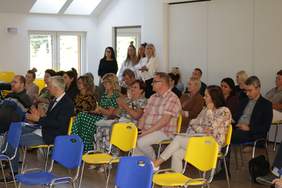 Pokaż zdjęcie: W sali na plastikowych różno kolorowych przesełkach siedzą osoby w różnym wielu. Są to przedstawiciele instytucji pomagających osobą niepełnosprawnym z terenu województwa pomorskiego.