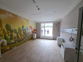 Sala dla podopiecznych hospicjum, kolorowa, z przygotowanym sprzętem do podłączenia urządzeń medycznych