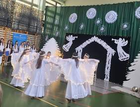 Pokaż zdjęcie: Dziewczynki-aniołki, ubrane na biało tańczą z podświetlonymi skrzydłami.