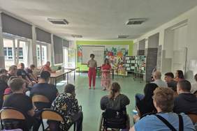 Pokaż zdjęcie: Z tyłu sali konferencyjnej w kierunku prelegentów. Prelegentki dwie kobiety.