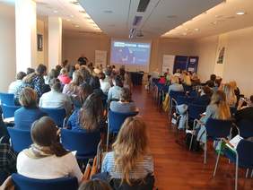 Pokaż zdjęcie: sala, uczestnicy konferencji siedzący w rzędach krzeseł. 