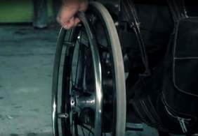 Widok fragmentu wózka inwalidzkiego - ujęcie z wideoklipu zespołu Skołowani