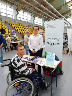 Pokaż zdjęcie: Pracownik Oddziału Świętokrzyskiego PFRON na stanowisku podczas Targów Pracy
