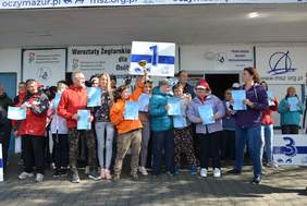 Pokaż zdjęcie: Grupa ludzi cieszących się i pokazujących puchary