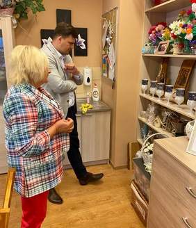 Pokaż zdjęcie: Kobieta i mężczyzna podziwiają różnorodne figurki, które ustawione są na regale