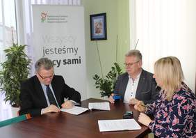 Pokaż zdjęcie: Podpisanie umowy przez Dyrektora ZUS w tle baner PFRON