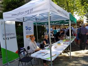 Pokaż zdjęcie: Stoisko informacyjne Małopolskiego Oddziału PFRON podczas uroczystości ku czci Przemienienia Pańskiego w Parafii św. Małgorzaty w Nowym Sączu
