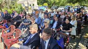 Pokaż zdjęcie: Zaproszeni goście siedzą na dziedzińcu podczas uroczystych obchodów 50-lecia Powiatowego Domu Pomocy Społecznej w Siemiatyczach. W słoneczny dzień w wydarzeniu uczestniczą pracownicy, przedstawiciele władz, instytucji i lokalnej społeczności.