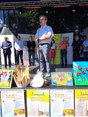 fotografia z uroczystego otwarcia XXII Opolskich Dni Osób Niepełnosprawnych - na scenie przemawia Pan Łukasz Żmuda - Dyrektor Opolskiego Oddziału PFRON