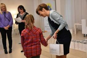 Pokaż zdjęcie: Anna Skupień, dyrektor Oddziału Wielkopolskiego PFRON wręcza upominki uczestnikowi konkursu fotograficznego „Ja i osoba niepełnosprawna” 