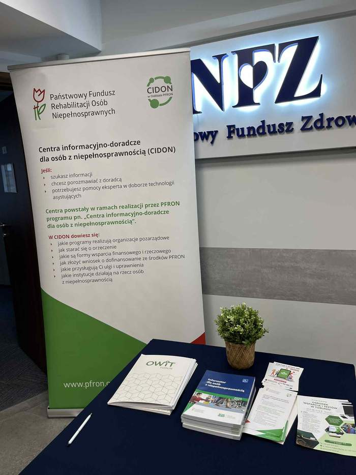 Biało-zielnony rollup z napisem Centra informacyjno-doradcze dla osób z niepełnosprawnością