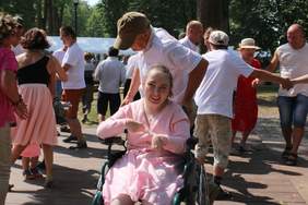 Pokaż zdjęcie: Uczestniczka festiwalu na wózku tańczy z pomocą opiekuna 