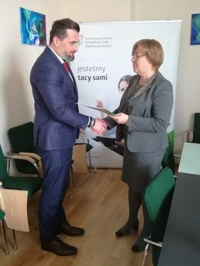 Pokaż zdjęcie: Paweł Kobielusz, Wicestarosta Powiatu Oświęcimskiego oraz Marta Mordarska, Dyrektor Małopolskiego Oddziału PFRON podczas podpisywania umowy na realizację Programu "Zajęcia Klubowe w WTZ"