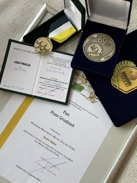 Pokaż zdjęcie: Na stoliku widać dyplomy i medale, które otrzymał Piotr Grudzień