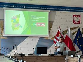 Pracownik CIDON w trakcie wystąpienia na tle prezentacji z mapą województwa lubuskiego