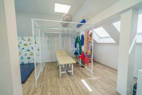 Pokaż zdjęcie: Sala rehabilitacyjna. W pomieszczeniu widoczne są różne sprzęty służące do zajęć rehabilitacyjnych.