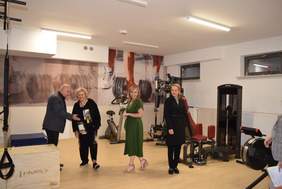 Pokaż zdjęcie: Na zdjęciu zdjęcie siłowni i osób oglądających sprzęt