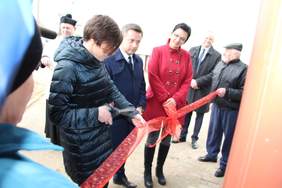 Pokaż zdjęcie: Przecięcie wstęgi przez Annę Skupień, dyrektora Oddziału Wielkopolskiego PFRON podczas uroczystości przekazania busa dla DPS w Chumiętkach