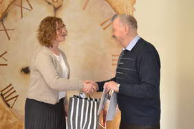 Pokaż zdjęcie: Na fotografii kobieta gratuluje mężczyźnie. Ściskają swoje dłonie