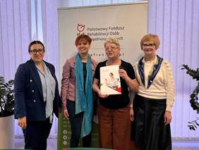 Pokaż zdjęcie: Na tle rollupu z logo PFRON pozują cztery kobiety.