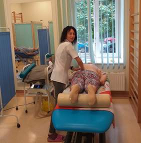 Pokaż zdjęcie: prowadzenie rehabilitacji w placówce: masażystka wykonuje masaż leczniczy uczestnikom projektu