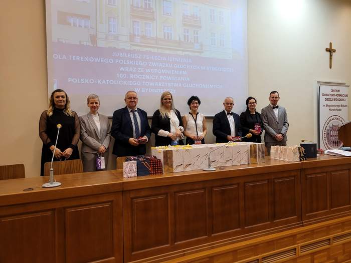 Pracownicy i członkowie koła PZG stoją na podium i przyjmują gratulacje