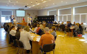 Pokaż zdjęcie: W sali konferencyjnej trwa spoptkanie informacyjne poświęcone programowi „Wyrównywanie różnic między regionami III” na rok 2026. Za stołami siedzą ludzie i słuchają wykładu. Na środku stoi prowadzący, a nad nim wisi tablica multimedialna. 