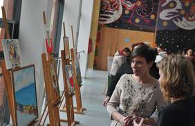 Pokaż zdjęcie: Anna Skupień, dyrektor Oddziału Wielkopolskiego wraz ze zwiedzającymi wystawę prac XV edycji Konkursu Plastycznego