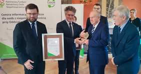 Pokaż zdjęcie: Senator Krzysztof Słoń wręcza nagrodę "Burzyciela Barier przedstawicielom Spółdzielni "Wanacja