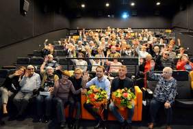 Pokaż zdjęcie: Grupa osób na widowni macha rękoma