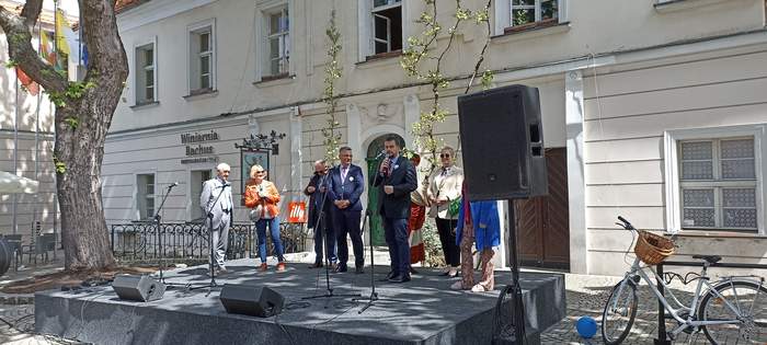 Pokaż zdjęcie: Na scenie przed zielonogórskim ratuszem stoją osoby witające gości