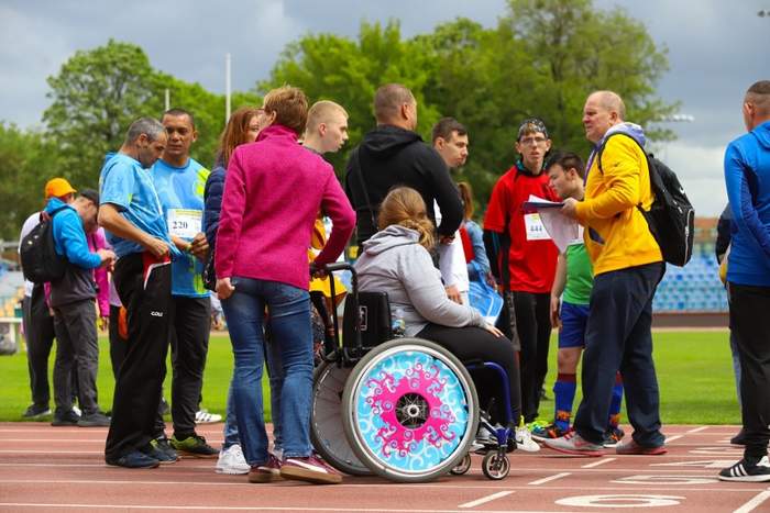 Uczestnicy XI Toruńskiej Olimpiady Osób Niepełnosprawnych na murawie stadionu