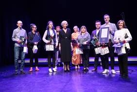 Pokaż zdjęcie: Na scenie stoi grupa osób z dyplomami, są to laureaci nagród prezydenta miasta Lublin