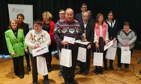 Pokaż zdjęcie: Małopolscy Laureaci konkursu "Sztuka osób niepełnosprawnych" - na scenie stoją laureaci oraz osoby wręczające nagrody