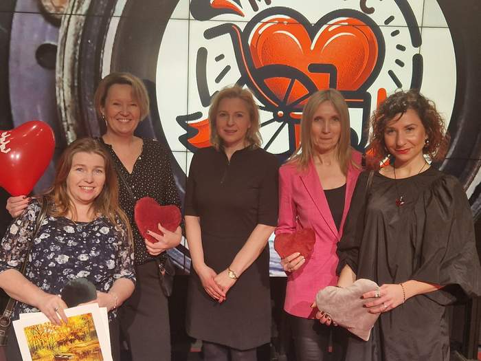 Pokaż zdjęcie: Pięć uśmiechniętych kobiet pozuje do pamiątkowego zdjęcia.