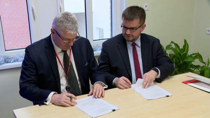 Pokaż zdjęcie: Dyrektor Oddziału PFRON w Zielonej Górze oraz Prezes Szpitala Uniwwersyteckiego podpisują umowę, obaj są ubrani w garniturach