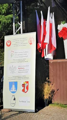 Baner promujący organizatorów oraz jednostki finansujące i sponsorujące festiwal, w tle flagi Polski