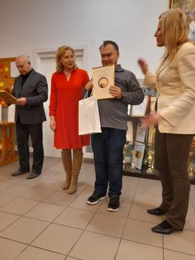 Pokaż zdjęcie: Mężczyzna pozuje do pamiątkowego zdjęcia z dyrekcją Oddziału Lubelskiego PFRON