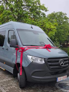 Pokaż zdjęcie: Zdjęcie niebieskiego auta marki Mercedes udekorowane kokardą.
