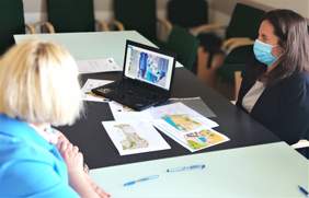 Pokaż zdjęcie: Uczestnicy spotkania siedzą przy stole w sali konferencyjnej, podpisują dokumenty. Na stole laptop z filmem o orientacji precyzyjnej