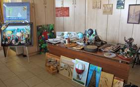 Pokaż zdjęcie: Prace plastyczne zgłoszone w kategorii rzeźba kameralna i płaskorzeźba wystawione na stole konferencyjnym 