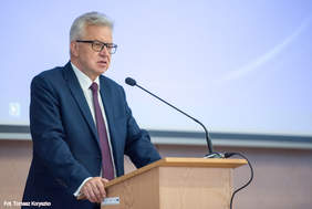 Pokaż zdjęcie: Minister przy pulpicie podczas wystąpienia do uczestników konferencji