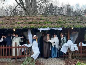 Pokaż zdjęcie: Na scenie występują aktorzy, którzy odgrywają jasełka. Są przebrani za Świętą Rodzinę, diabłów, aniołów i królów. Przedstawienie odbywa się w szopce na dworze. 