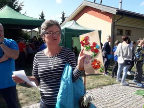 Pokaż zdjęcie: Uczestniczka warsztatów prezentuje obraz - witraż szklany przedstawiający kwiaty